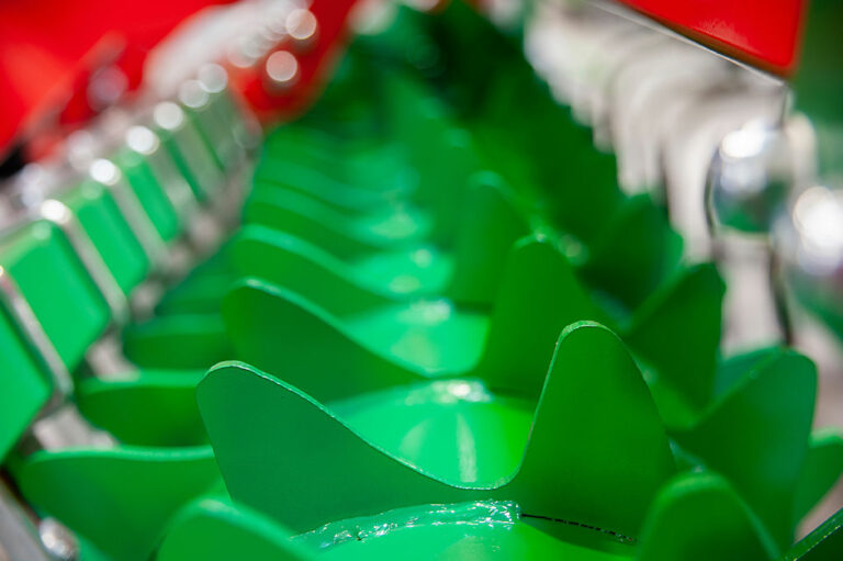 Close-up of a green and red agricultural machin