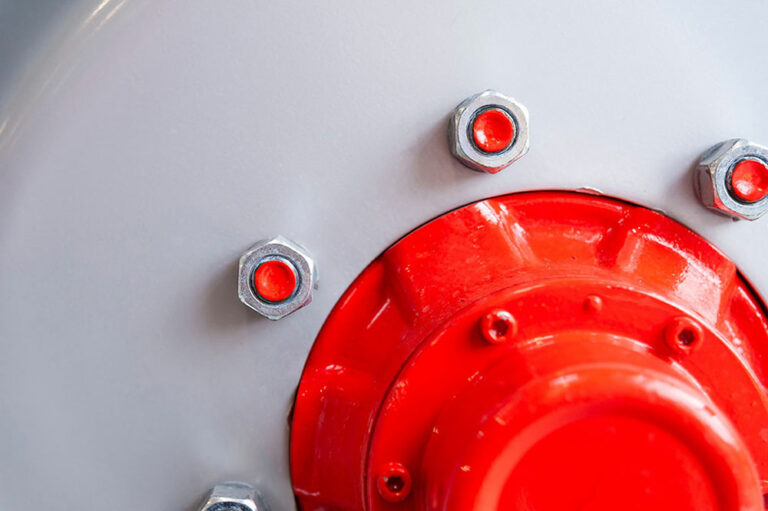 "Close-up of a tractor wheel rim with flawless red and gray surface, bolts and nuts visible – AI-generated image