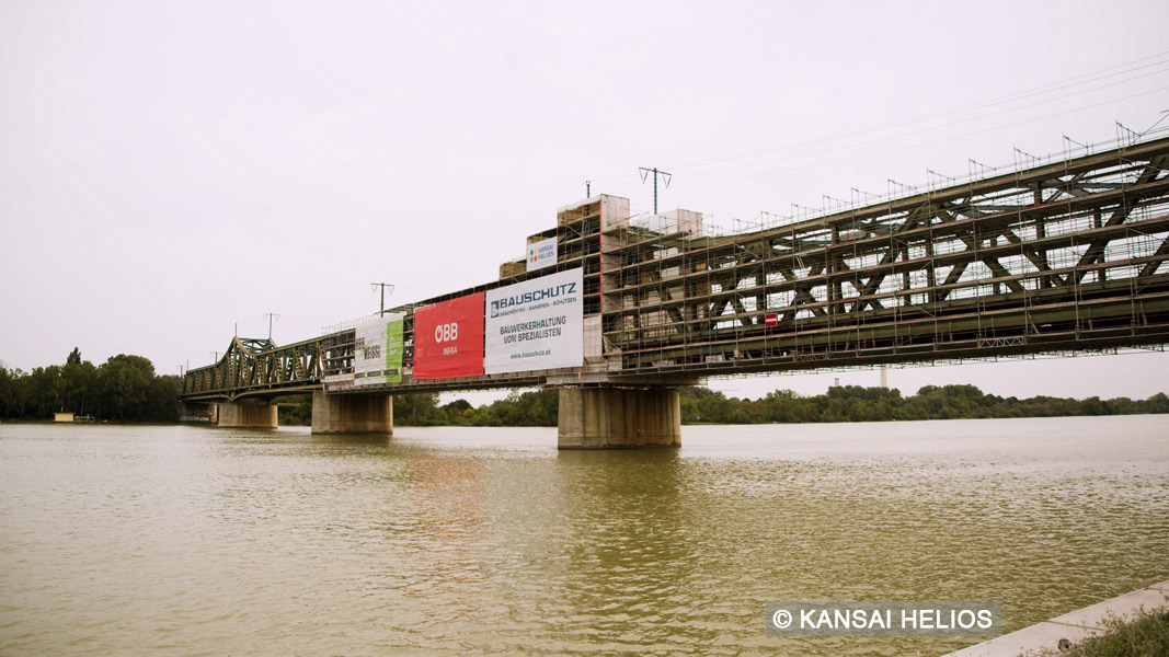 steel bridge with construction fence posters
