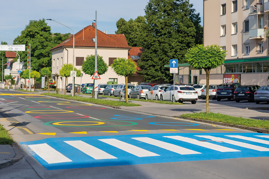 Blue and white road crossing with colourful road marking circles