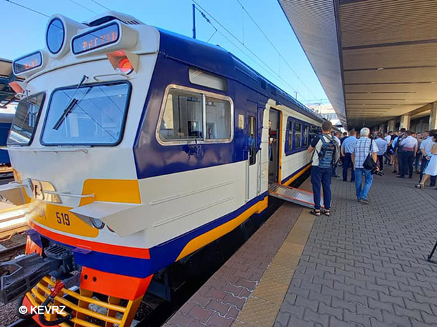 Blue and white regional train at a station platform with passengers boarding and disembarking