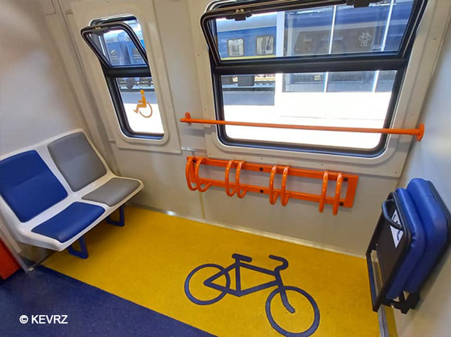 Bicycle storage area inside a passenger train with dedicated bike racks and accessible seating