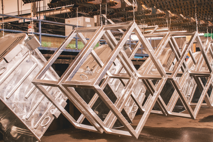 Liquid_Dip_Coating Large metal objects hanging on a coating line before being dipped into the coating.