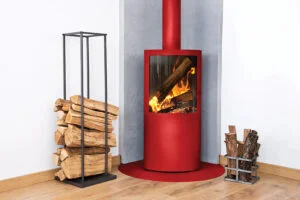 Red-Oven Red fireplace, surrounded by neatly stacked firewood in minimalist metal holders.
