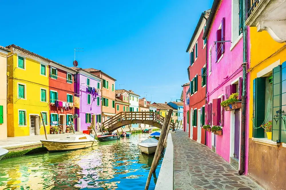 colored-city Colorful facades of traditional houses along a canal in Burano, Italy, showcasing vibrant exterior paints.