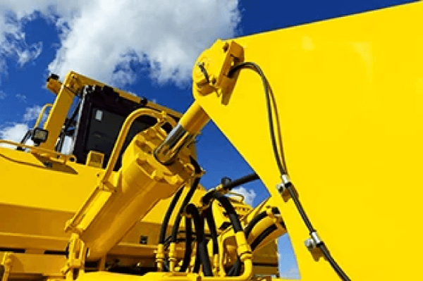 Close-up of hydraulic parts on a yellow construction vehicle – industrial coatings for heavy-duty equipment.