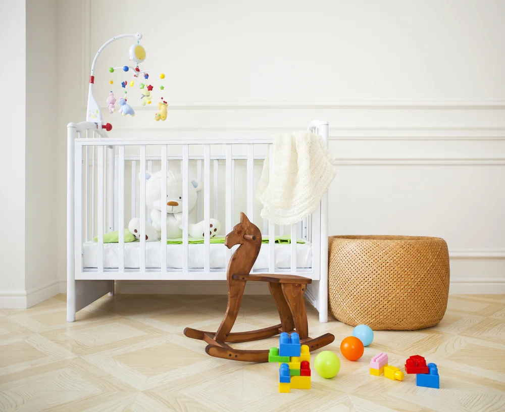 nursery-room child bed and wooden horse toy