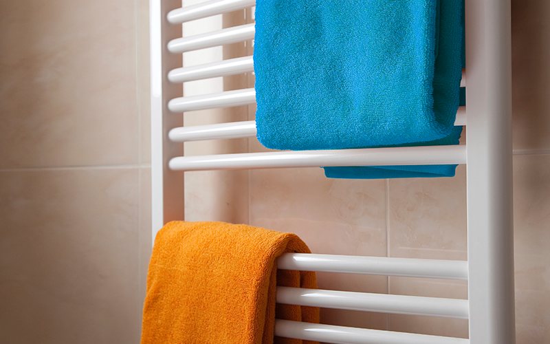 powder-heating towel rack with a blue and an orange towel hanging on it