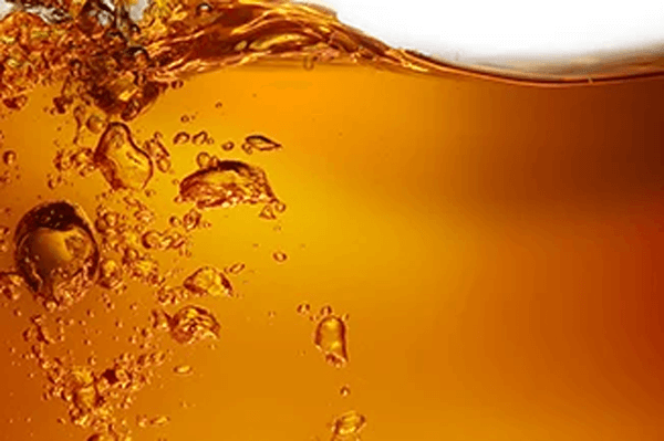Bubbling orange chemical liquid with air pockets – performance chemicals for industrial and resin applications.