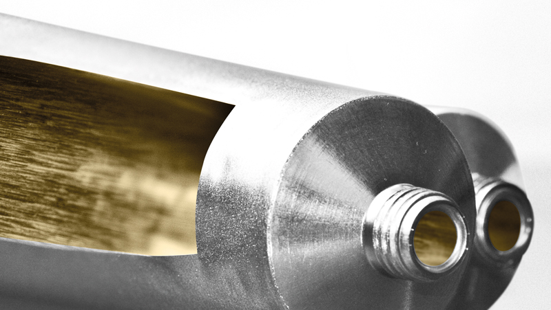 weilburger-coatings-protaral-classic-c_1 A close-up of two cylindrical metal components with threaded ends and a cutout revealing a golden interior.